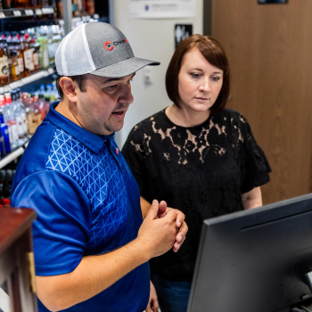 A man talks with a woman near a credit card processor for liquor stores.